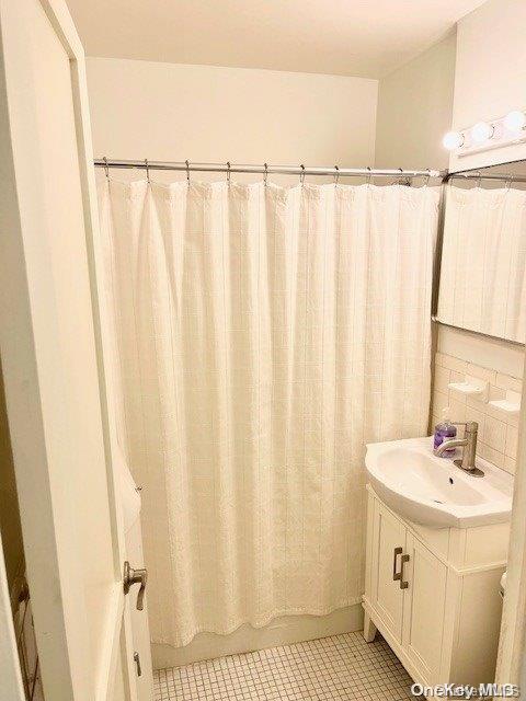 bathroom featuring vanity, tasteful backsplash, and tile patterned floors