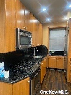 kitchen with sink, dark wood-type flooring, and range