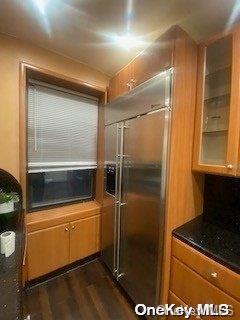 kitchen featuring dark hardwood / wood-style flooring, stainless steel built in fridge, and cooling unit