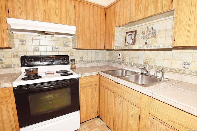 kitchen with white range with electric cooktop, decorative backsplash, sink, and tile counters