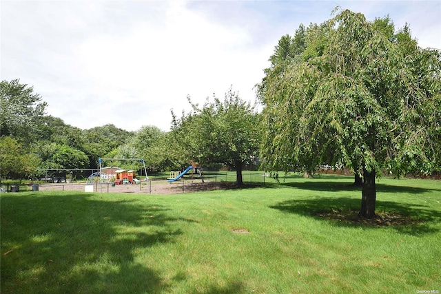 view of community featuring a playground and a lawn