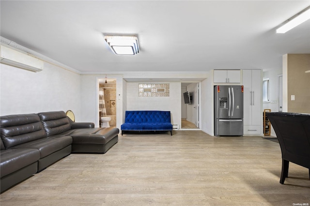 living room featuring a wall mounted AC and light hardwood / wood-style floors