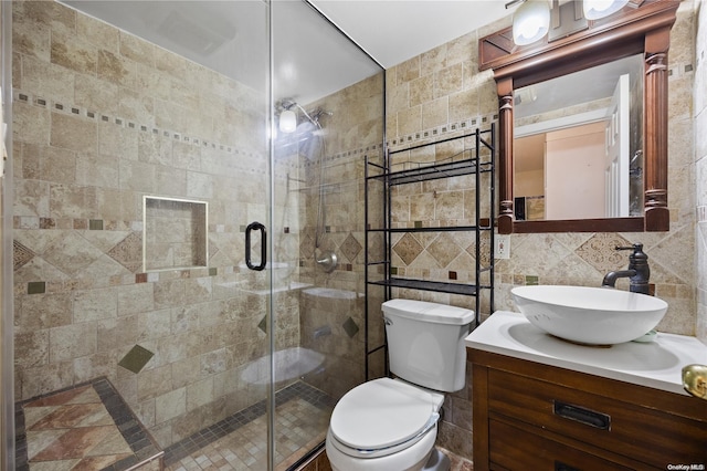 bathroom featuring decorative backsplash, vanity, a shower with door, tile walls, and toilet