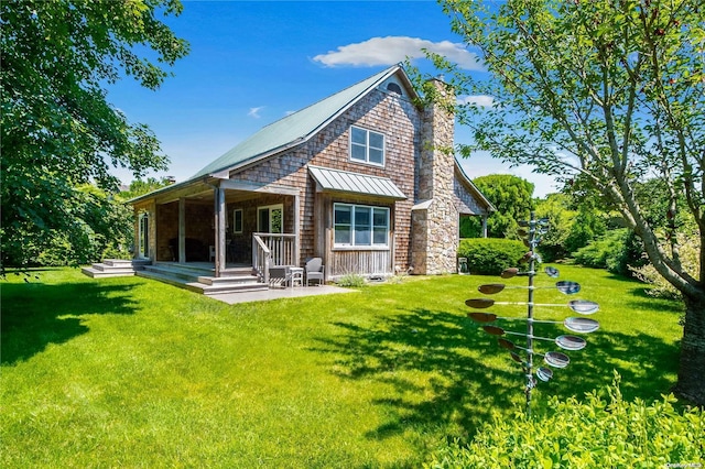 rear view of house featuring a lawn and a patio