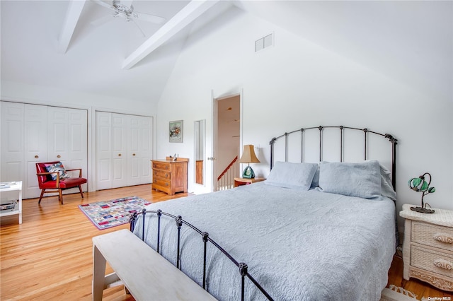 bedroom with hardwood / wood-style floors, ceiling fan, beam ceiling, and high vaulted ceiling