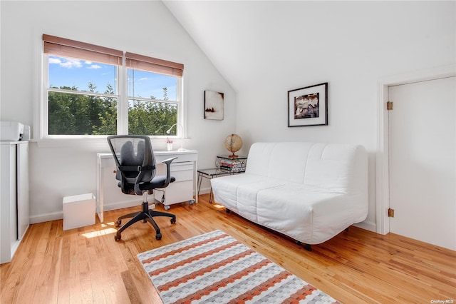 home office featuring lofted ceiling and light hardwood / wood-style flooring