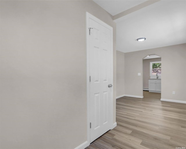 hallway featuring light hardwood / wood-style floors and a baseboard heating unit