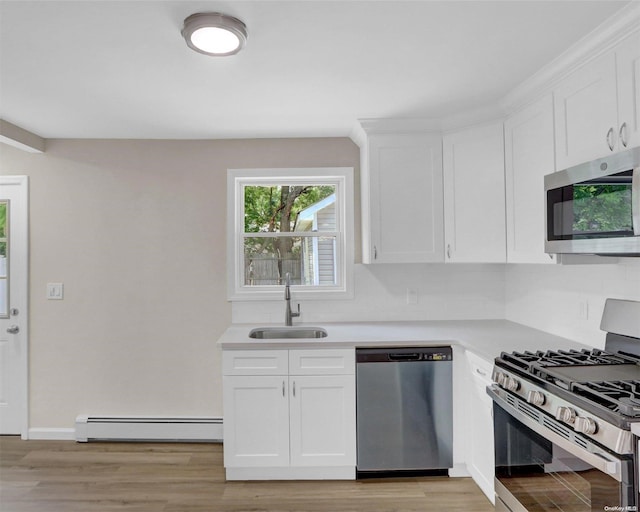 kitchen featuring white cabinetry, sink, baseboard heating, and stainless steel appliances