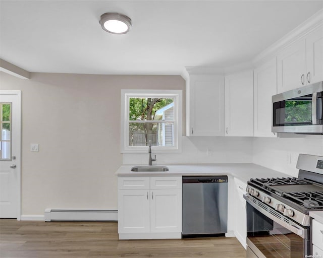 kitchen with sink, a baseboard radiator, light hardwood / wood-style floors, white cabinetry, and stainless steel appliances