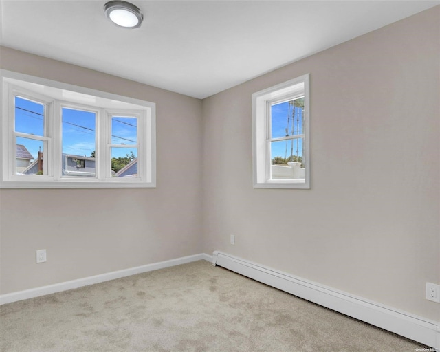 carpeted spare room with baseboard heating and plenty of natural light