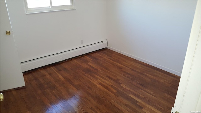 unfurnished room with dark hardwood / wood-style floors and a baseboard heating unit