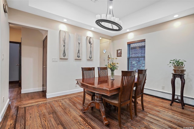 dining area featuring dark hardwood / wood-style floors and a baseboard heating unit