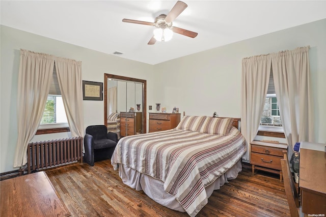 bedroom featuring radiator heating unit, ceiling fan, and dark wood-type flooring