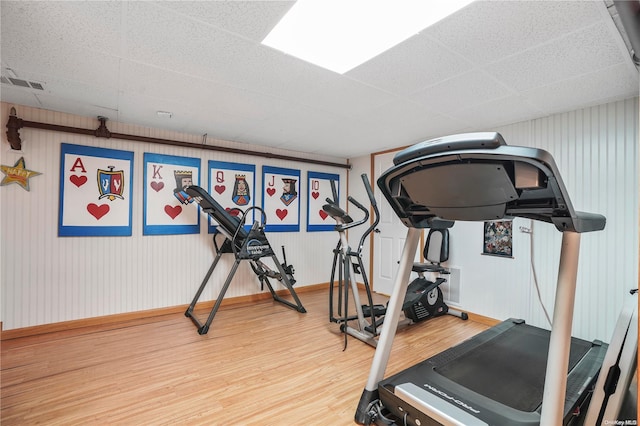 exercise room featuring hardwood / wood-style flooring and a drop ceiling