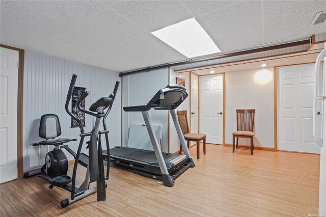 exercise area with hardwood / wood-style floors and a drop ceiling