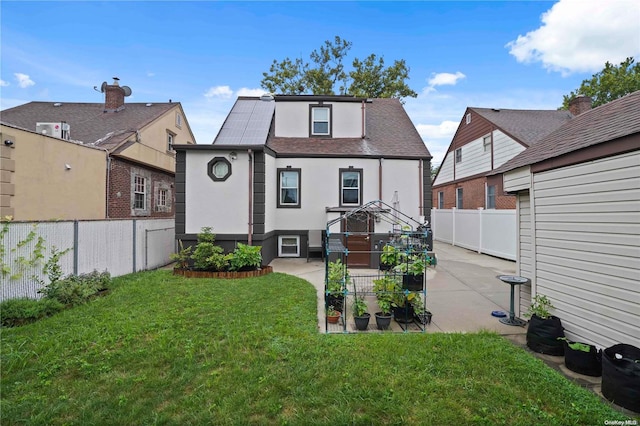 back of property with a lawn and a patio