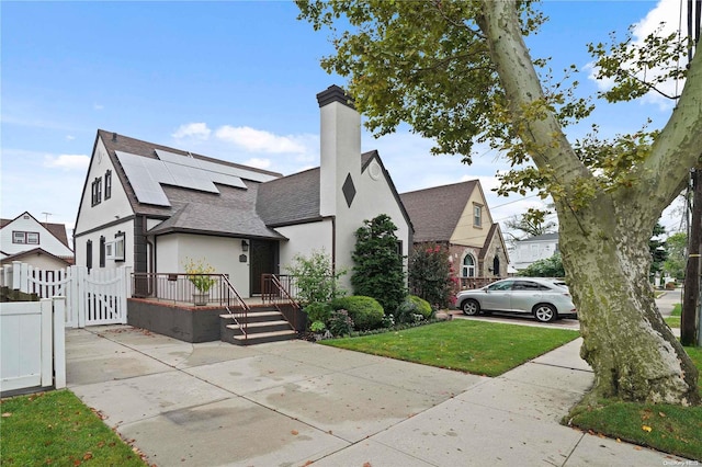 view of front of property with a front yard and solar panels