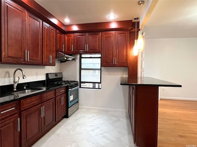 kitchen with light wood-type flooring, a breakfast bar, black range with gas stovetop, sink, and pendant lighting