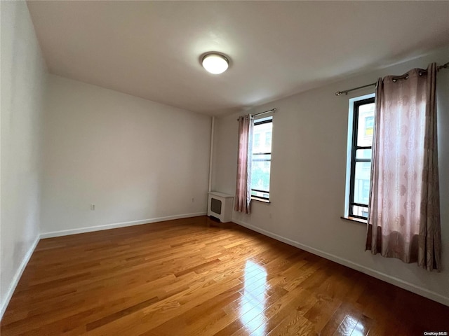 spare room featuring heating unit and light hardwood / wood-style flooring