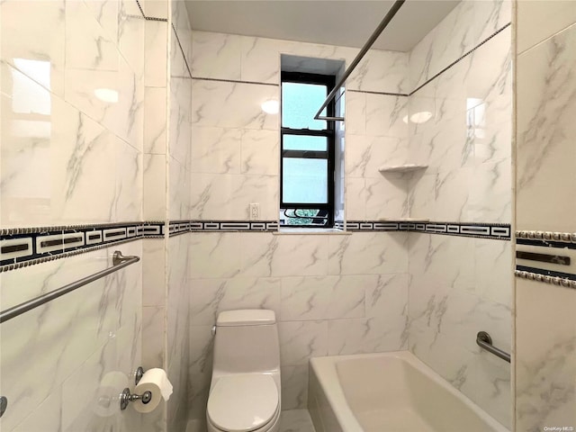 bathroom featuring tiled shower / bath, toilet, and tile walls