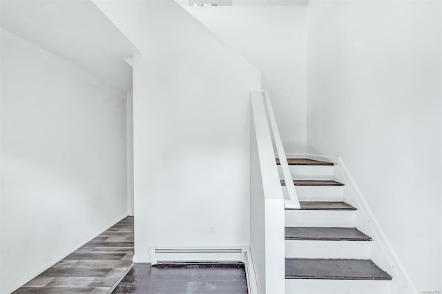 staircase featuring wood-type flooring and a baseboard radiator