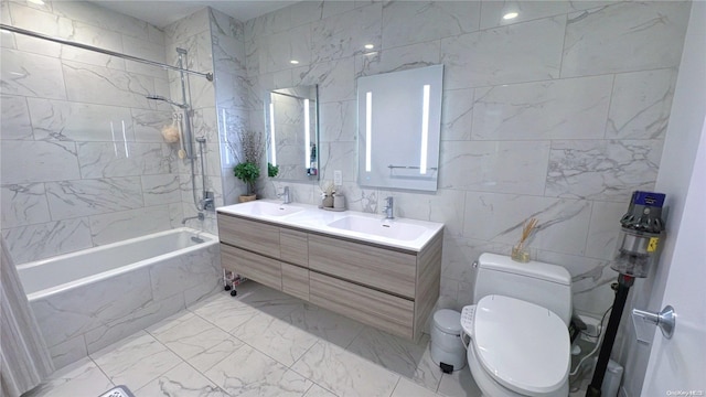 full bathroom featuring tile walls, vanity, tiled shower / bath combo, and toilet