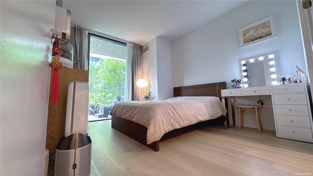 bedroom featuring access to exterior and light hardwood / wood-style floors