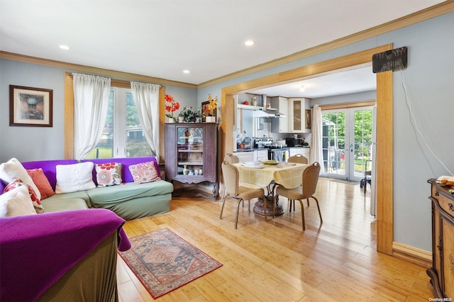 living room featuring crown molding, plenty of natural light, french doors, and light wood-type flooring