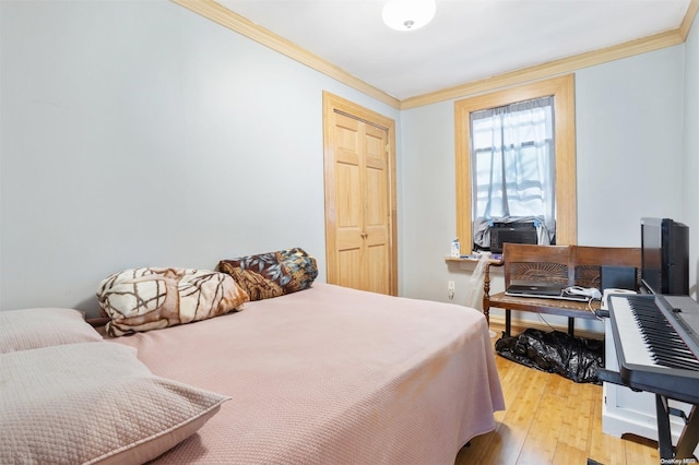 bedroom with crown molding, a closet, and light wood-type flooring