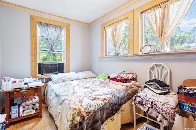 bedroom featuring multiple windows, cooling unit, light hardwood / wood-style floors, and ornamental molding