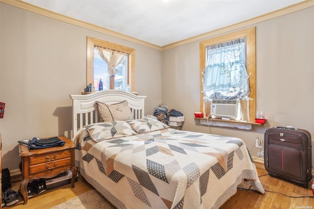 bedroom with light hardwood / wood-style flooring, cooling unit, and ornamental molding