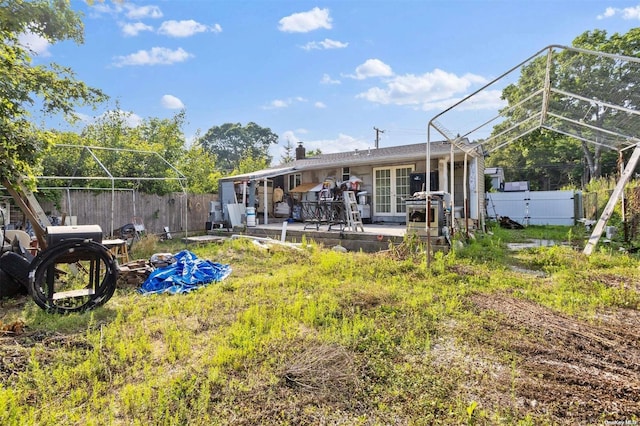 view of yard featuring french doors, a patio, and glass enclosure