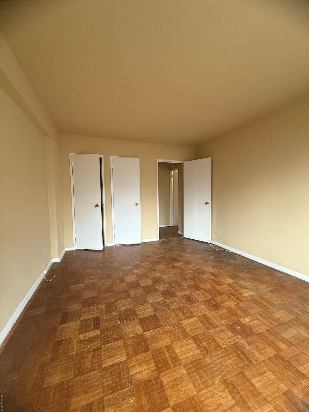 unfurnished bedroom featuring parquet flooring