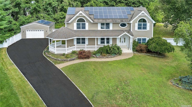 view of front of property with solar panels, covered porch, a front lawn, a garage, and an outdoor structure