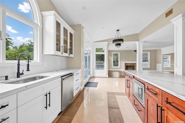 kitchen featuring a wealth of natural light, sink, appliances with stainless steel finishes, and vaulted ceiling