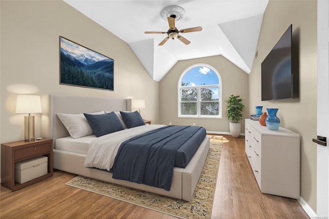 bedroom with ceiling fan, light hardwood / wood-style flooring, and vaulted ceiling