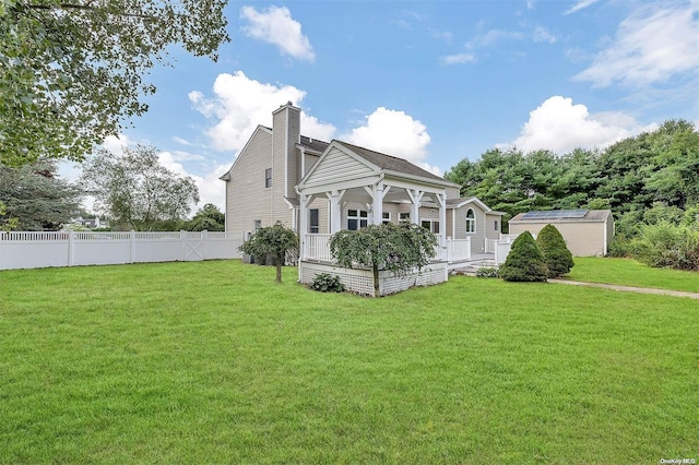 back of property with a lawn and a porch