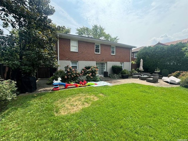 back of property featuring a patio area, a yard, and an outdoor hangout area