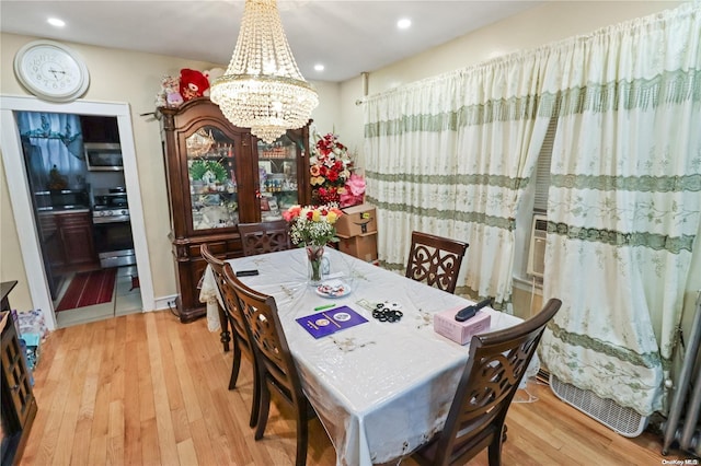 dining room with wood-type flooring and an inviting chandelier