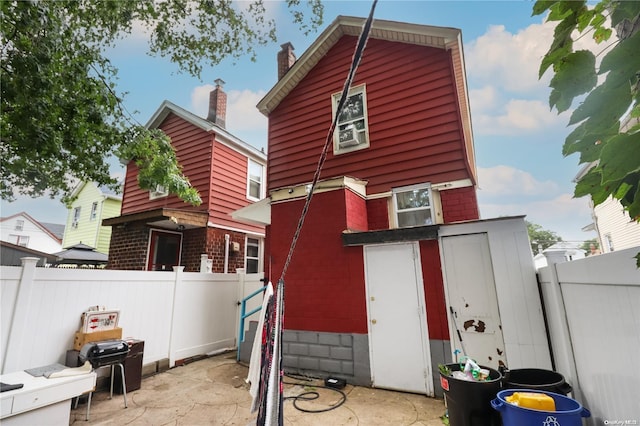 back of property featuring a patio and a storage unit