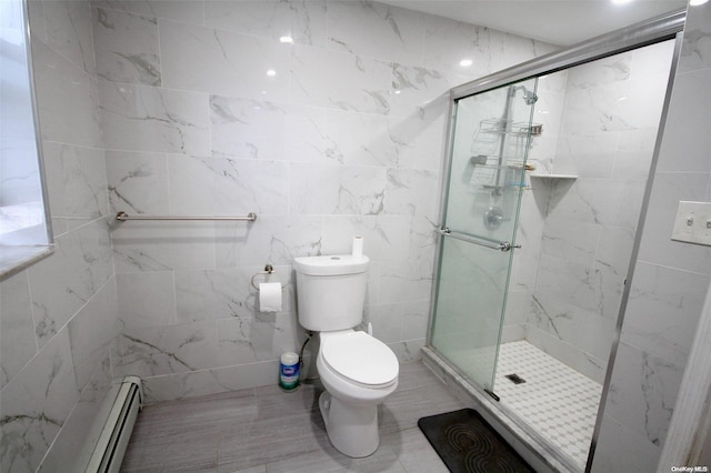 bathroom featuring toilet, a shower with door, tile walls, and a baseboard heating unit