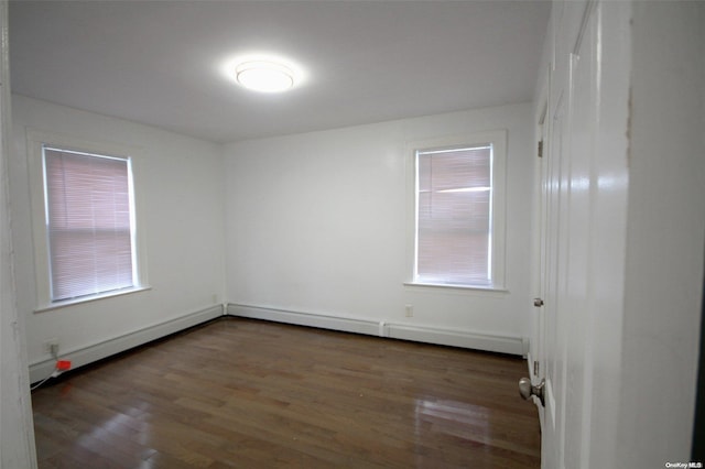 empty room featuring plenty of natural light and dark wood-type flooring