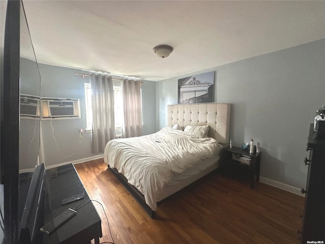 bedroom with an AC wall unit and dark wood-type flooring