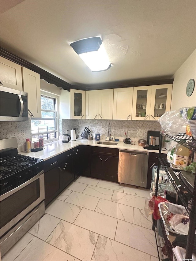 kitchen with white cabinets, stainless steel appliances, tasteful backsplash, and sink