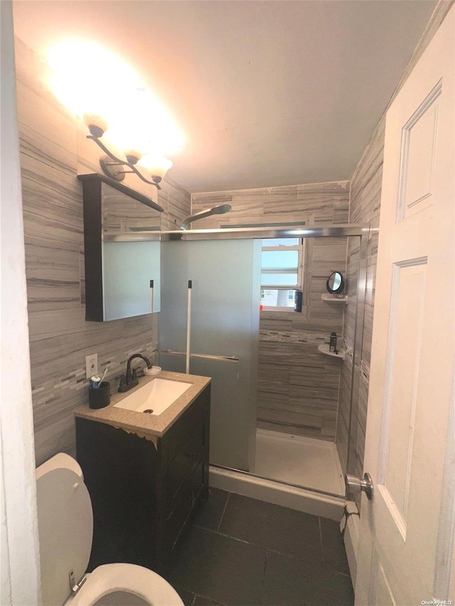 bathroom with tile patterned floors, vanity, toilet, and an enclosed shower