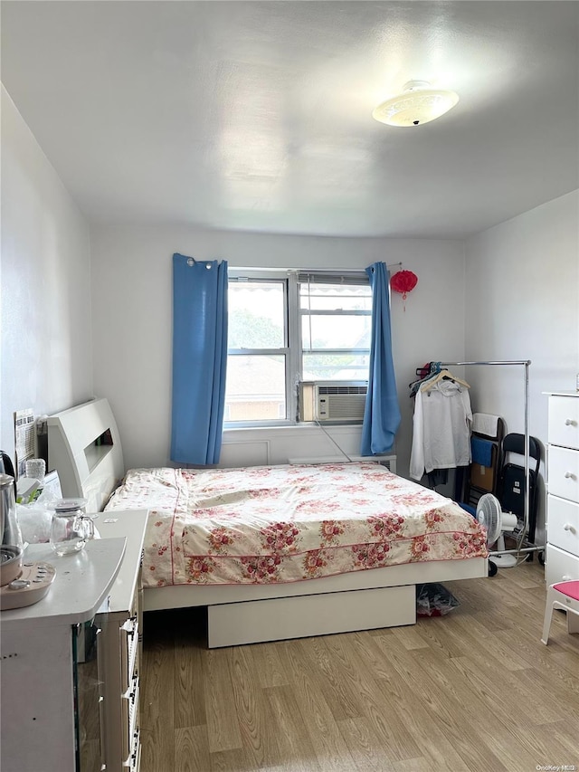 bedroom featuring cooling unit and light hardwood / wood-style floors