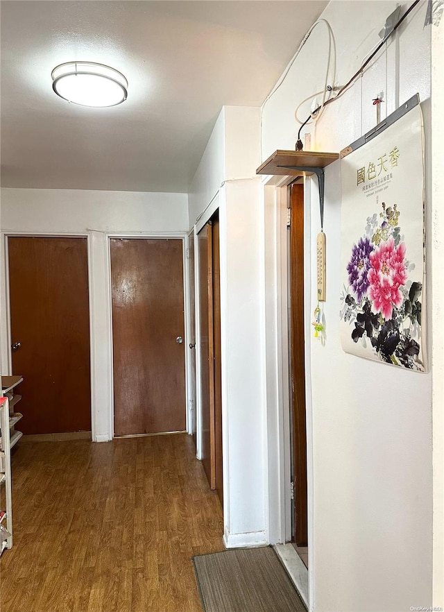 corridor with hardwood / wood-style floors