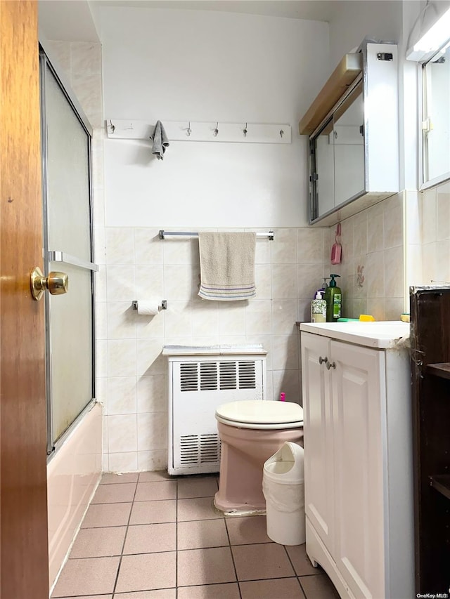 full bathroom with tile patterned floors, radiator, vanity, and tile walls