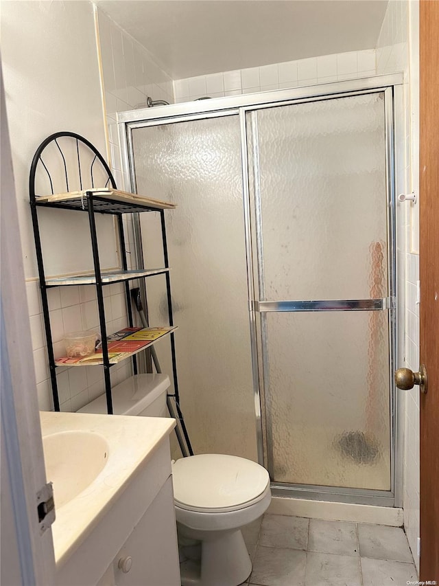 bathroom featuring a shower with door, vanity, and toilet