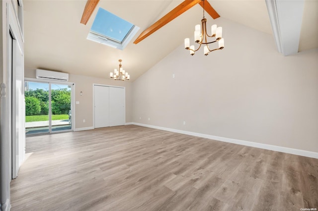 spare room featuring a skylight, light wood-type flooring, high vaulted ceiling, and a wall mounted AC